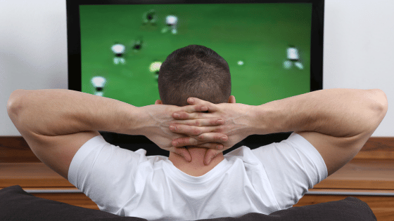 Young man watching football on IPTV